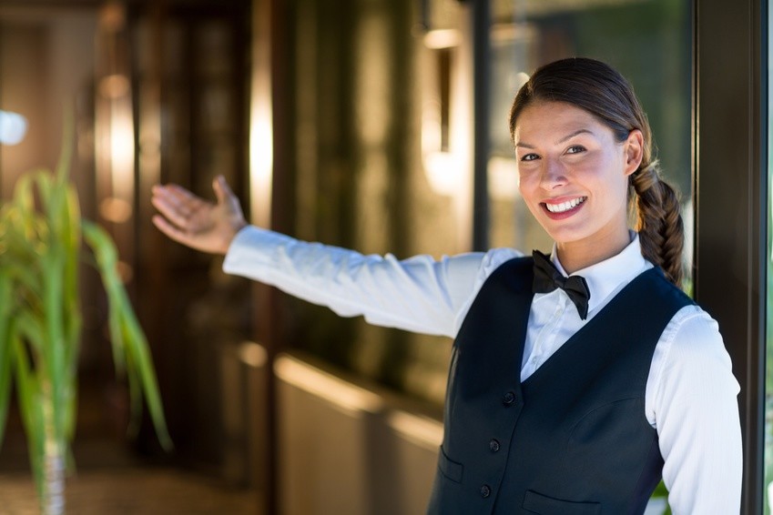 Portrait Of Smiling Waitress Welcoming Letsgoactive